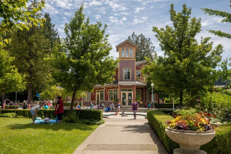 A number of people in a park next to a community centre.