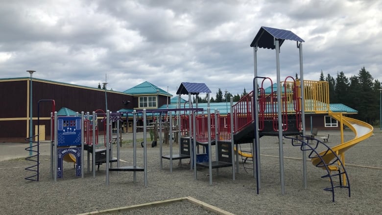 A large play structure is seen in a school playground.