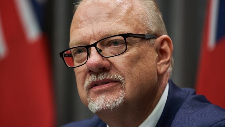 Head-and-shoulders photo of a man wearing a suit and glasses, with a closely cropped grey hair and goatee.