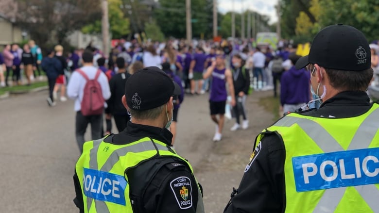 police officers watching students at a street party