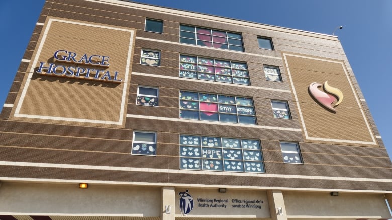 The exterior of a brown building is seen against the backdrop of a blue sky. The building is Grace Hospital.