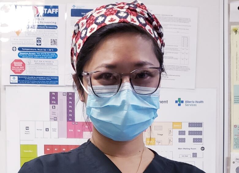 Dr. Katie Lin, wears a mask, glasses and surgical cap as she looks into the camera.