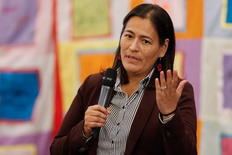 Michle Audette, a former commissioner for the National Inquiry into Missing and Murdered Indigenous Women and Girls, holds a microphone.