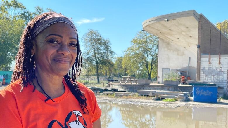 A woman stands in front of a derelict bandshell