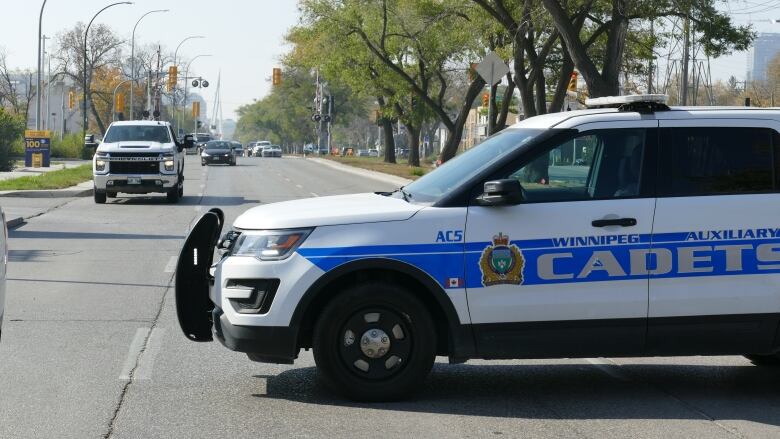 A police cadet vehicle blocks a roadway.