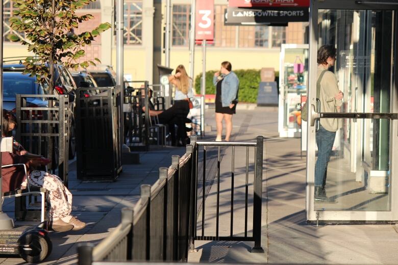 People stand on a paved boulevard in early autumn.