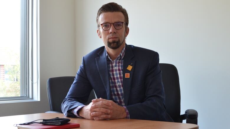 A man wearing a suit sits at a table.