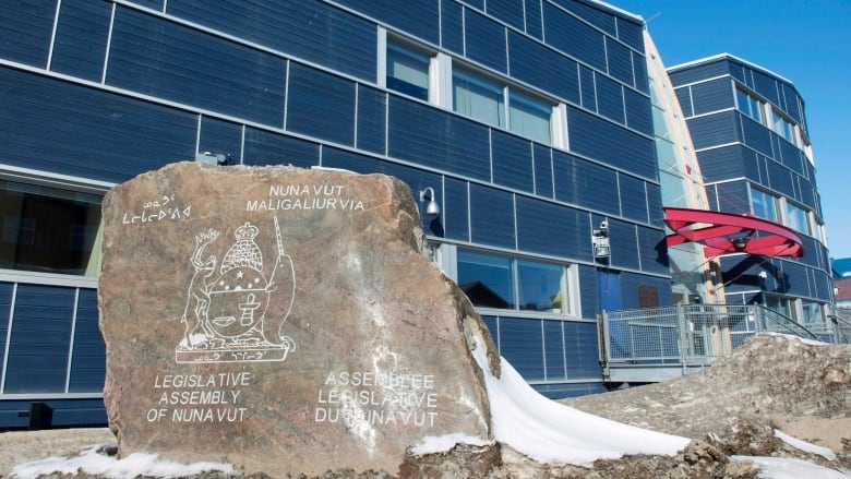 A blue building with a decorative rock in front of it