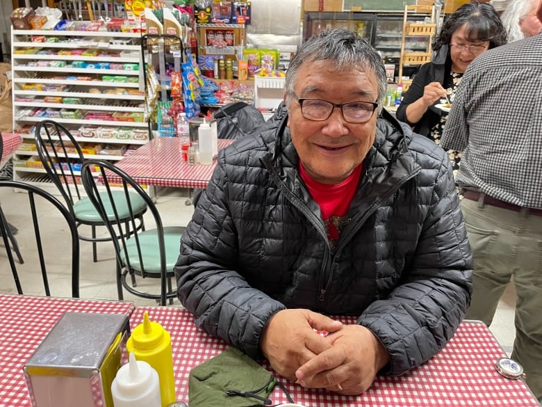 A smiling man sits at a table.