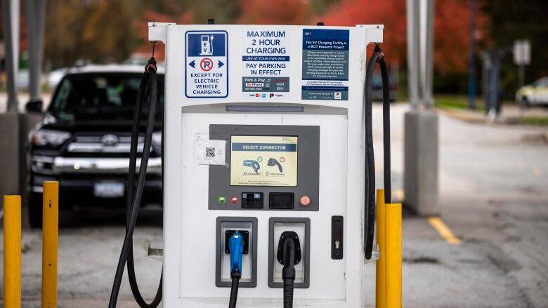 An electric vehicle charging station is pictured under a solar panel.