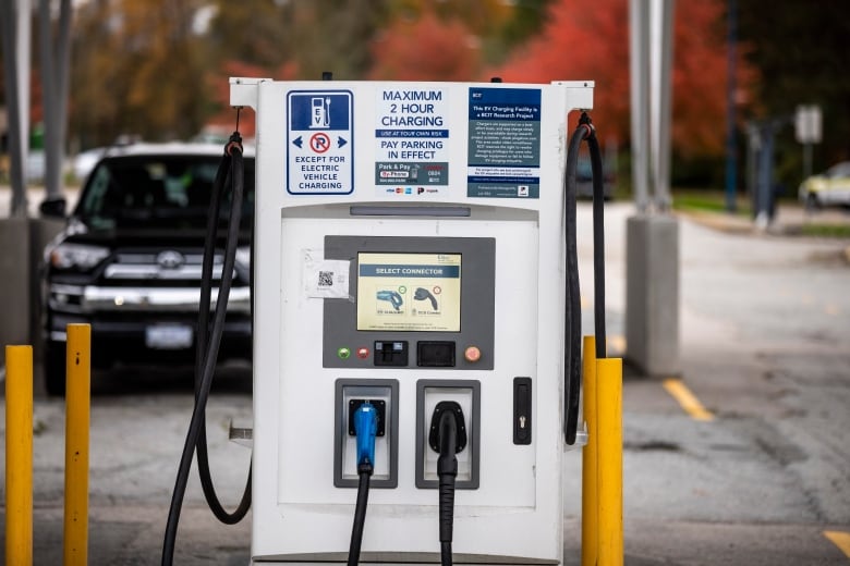 An electric vehicle charging station is pictured under a solar panel.