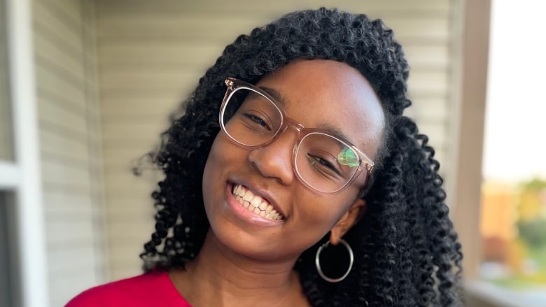 A Black girl with dark curly hair smiling