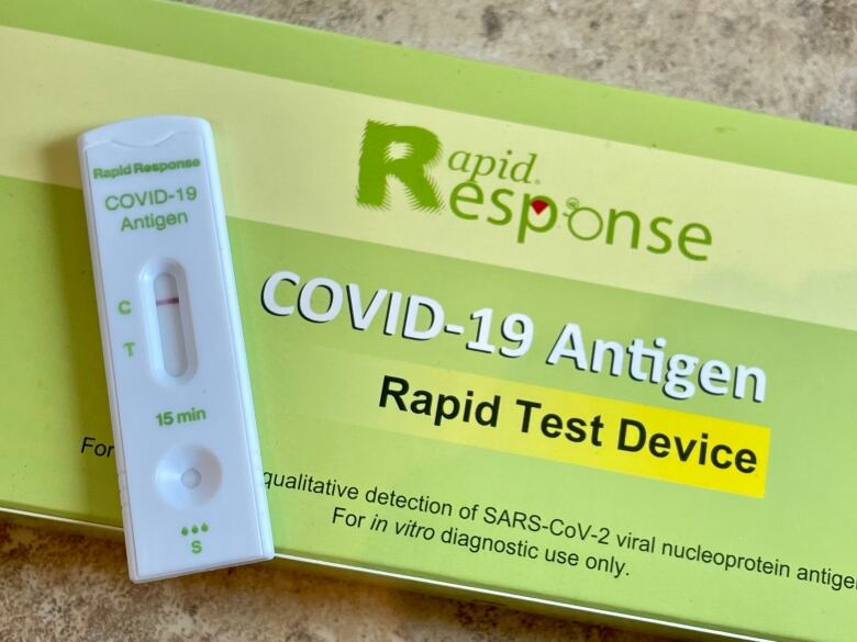 A close-up of a COVID-19 rapid test kit and device, showing a negative result.