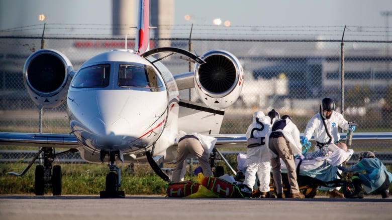 A patient from Saskatchewan is transferred from an air ambulance to a waiting Peel Region ambulance at Pearson airport in Toronto