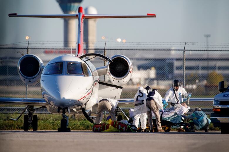 A patient from Saskatchewan is transferred from an air ambulance to a waiting Peel Region ambulance at Pearson airport in Toronto