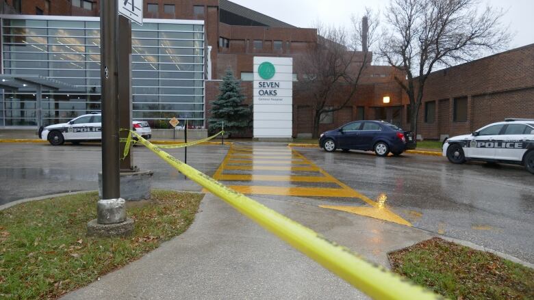 Police tape cordons off a hospital entrance.