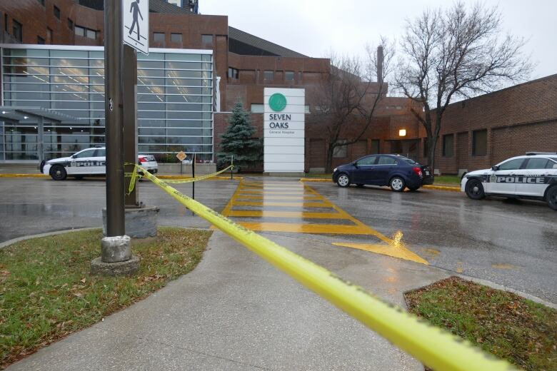 Police tape cordons off a hospital entrance.