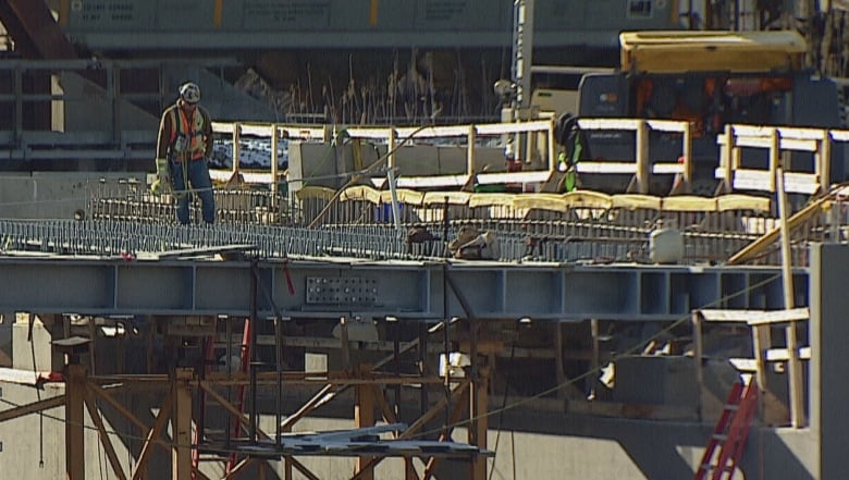 a bridge is pictured with a man in construction gear