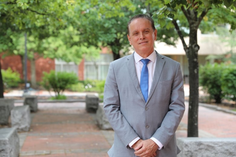 a man stands up wearing a suit.