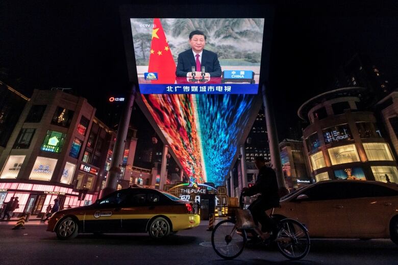 FILE PHOTO: A screen displays a CCTV state media news broadcast showing Chinese President Xi Jinping addressing world leaders at the G20 meeting in Rome via video link at a shopping mall in Beijing, China, October 31, 2021.  