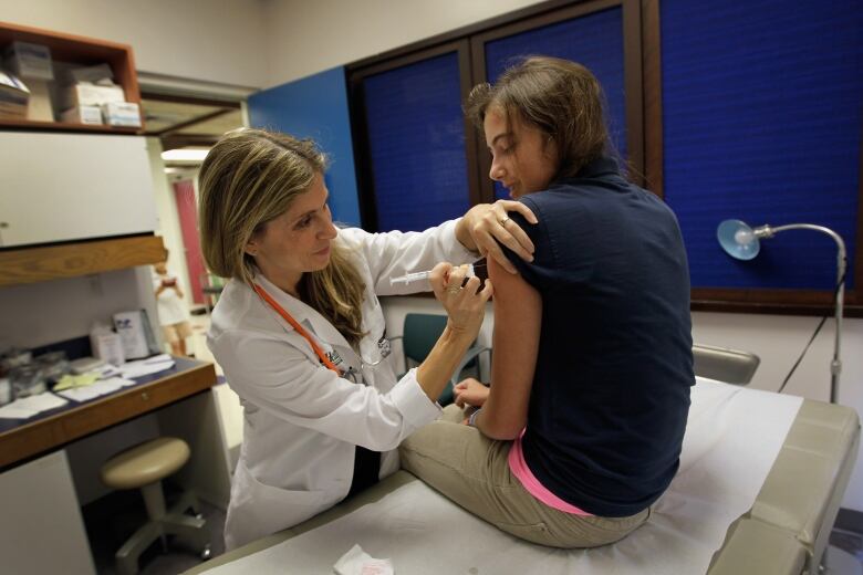 A 13-year-old girl gets the vaccine to prevent infections for the human papillomavirus, or HPV, that can cause cancer. 