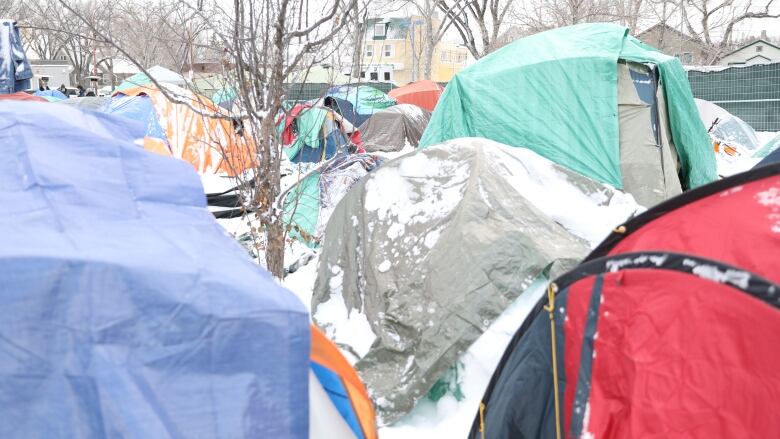 rows of tents outdoors, covered in snow