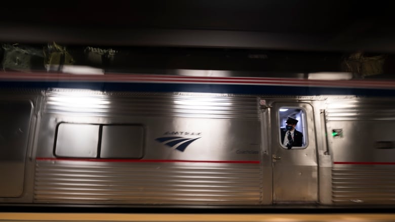 An Amtrak employee looks out the window as the train pulls out of the station on Friday, June 11, 2021, at Lincoln Station, in Lincoln, Neb.