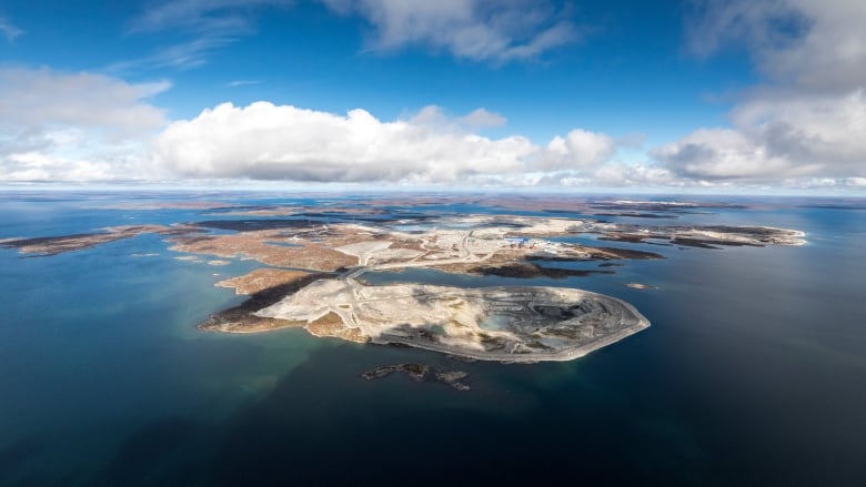 Aerial photo of open pits on an island surrounded by blue water.