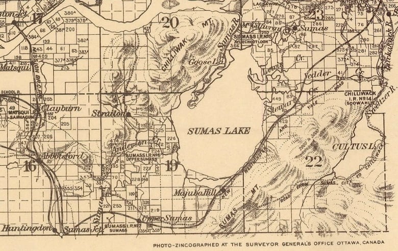 A topographical map showing a somewhat circular Sumas Lake in the middle. 