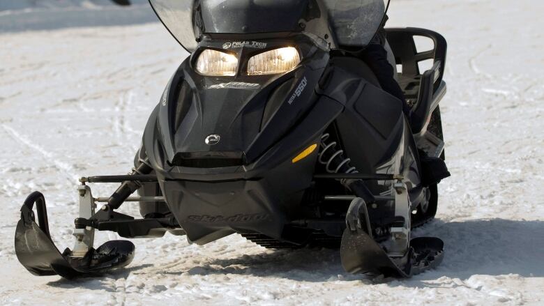 A snowmobile is seen travelling on a frozen lake.