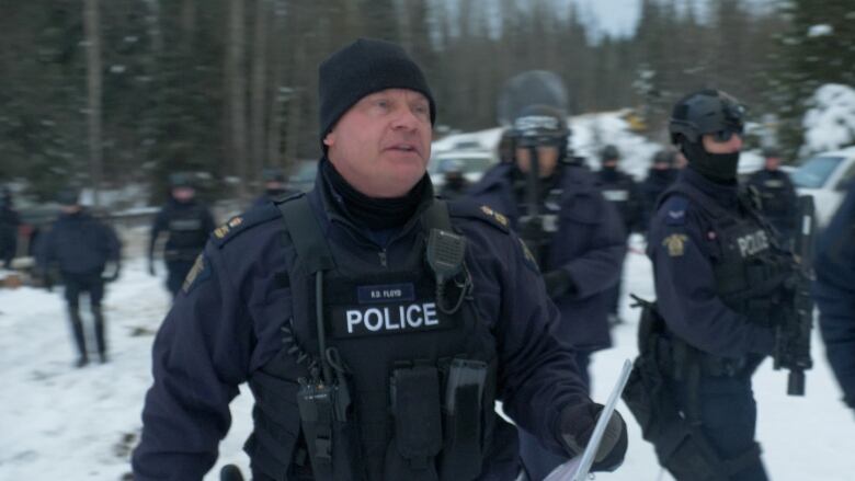 RCMP officers dscatter on a snowy road. 