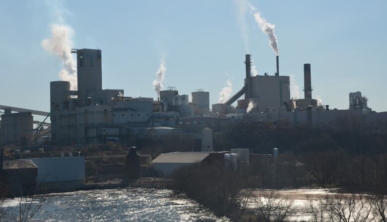 A factory building is seen, set beside a river.