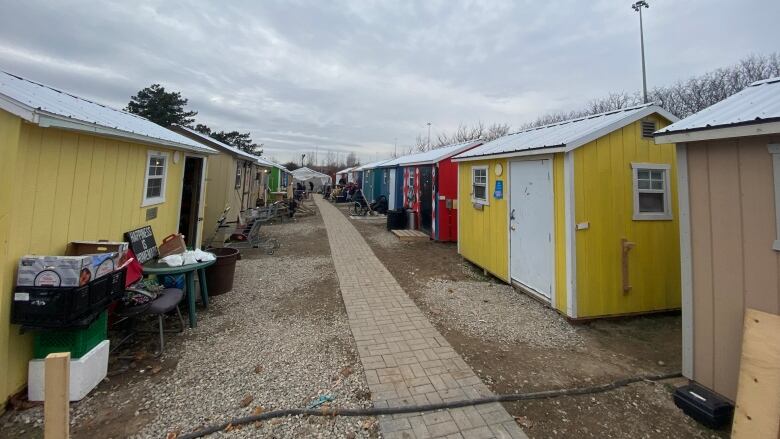 A thin path with a row of tiny homes on each side.