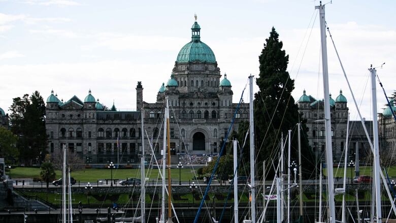 The B.C. Legislature building beneath a number of yachts in the harbour.