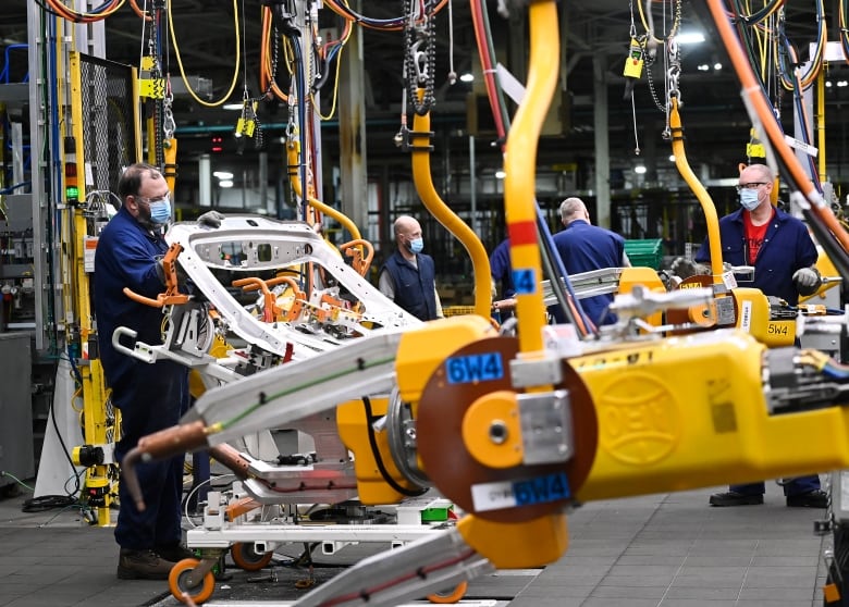 Workers in masks are pictured at the General Motors assembly plant.