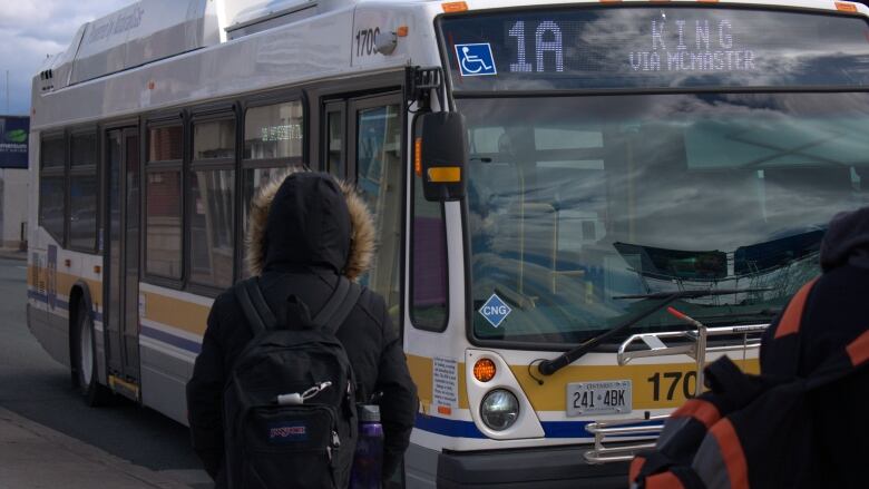 A person standing near a bus.