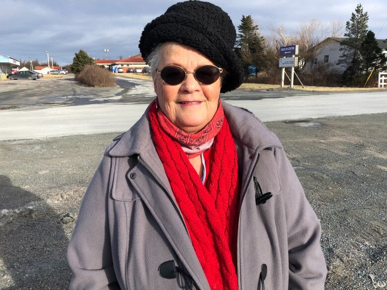 An older woman smiles for the camera.