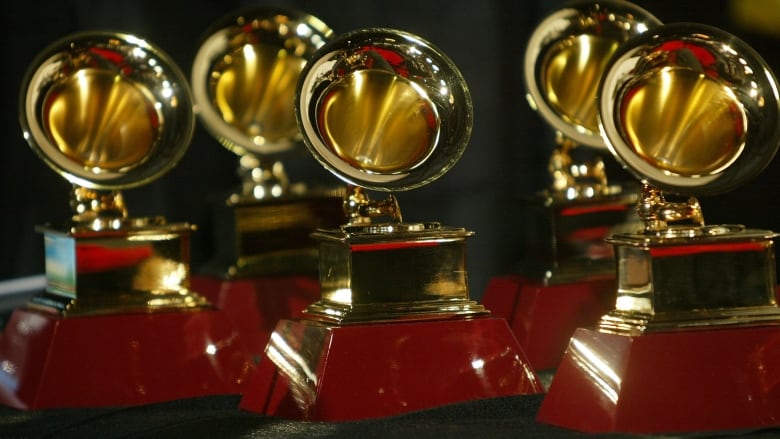 Five Grammy Award statues sit on a table.