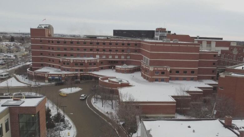 An aerial drone shot showing a the snowy hospital grounds. 