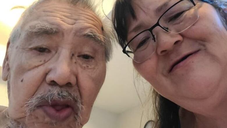 An elder sitting beside his daughter