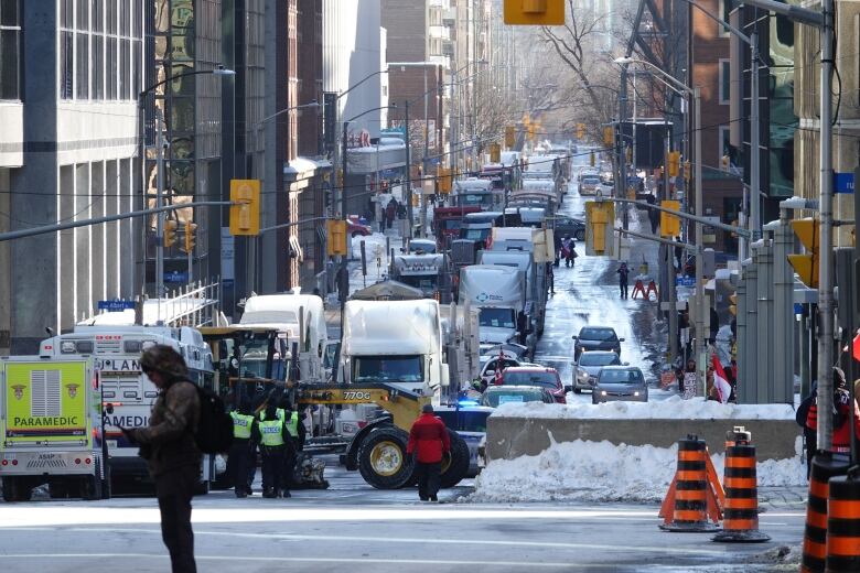 A line of parked trucks for blocks of a downtown city street in winter.