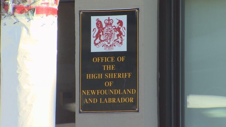 A sign on a concrete pillar reads Office of the High Sheriff of Newfoundland and Labrador. 