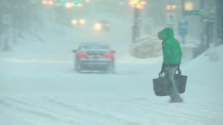 A pedestrian navigates snow-clogged streets