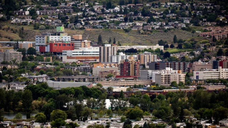 A sprawling array of commercial and residential buildings in a hilly area.