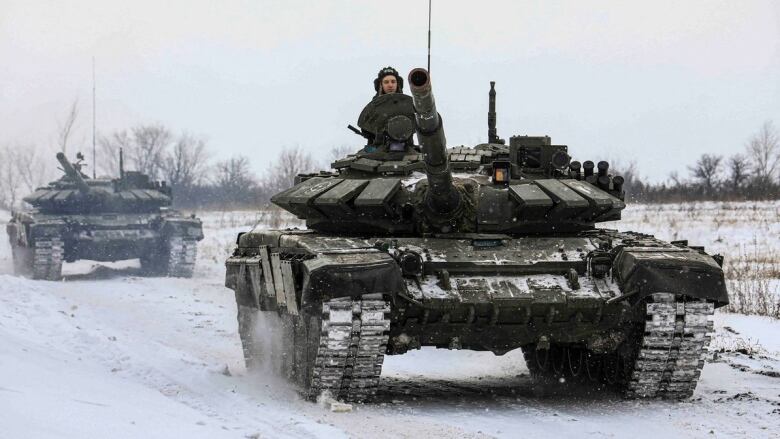 Russian servicemen drive tanks during military exercises in the Leningrad Region, Russia, in this handout picture released February 14, 2022. 