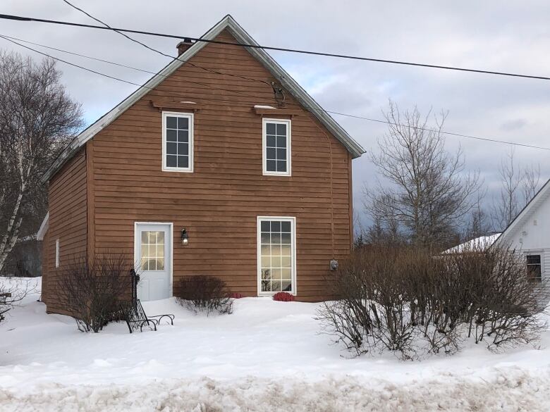 The front of a brown house in the winter time