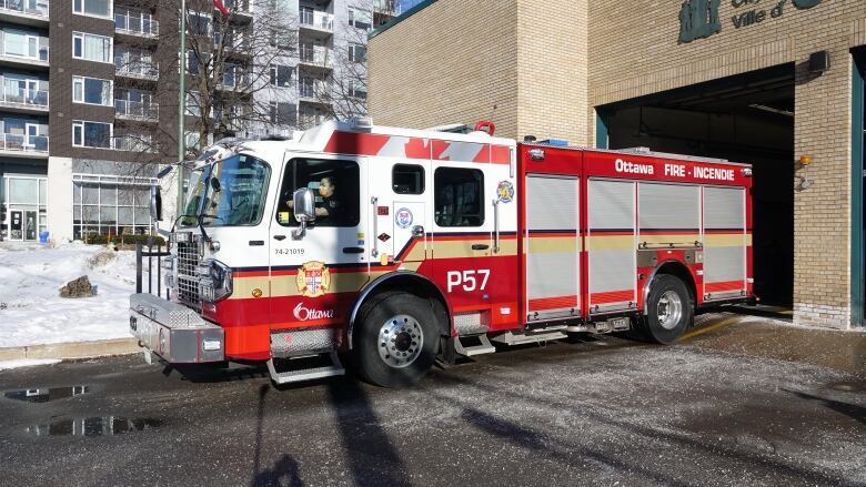 A fire truck on a driveway in winter.