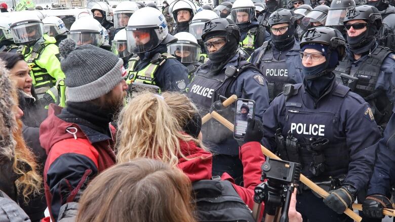 A group of protesters face off against police.