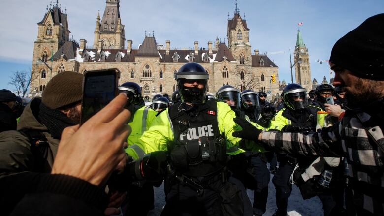 Police enforce an injunction against protesters, some who have been camped in their trucks near Parliament Hill for weeks, on Feb. 19, 2022.