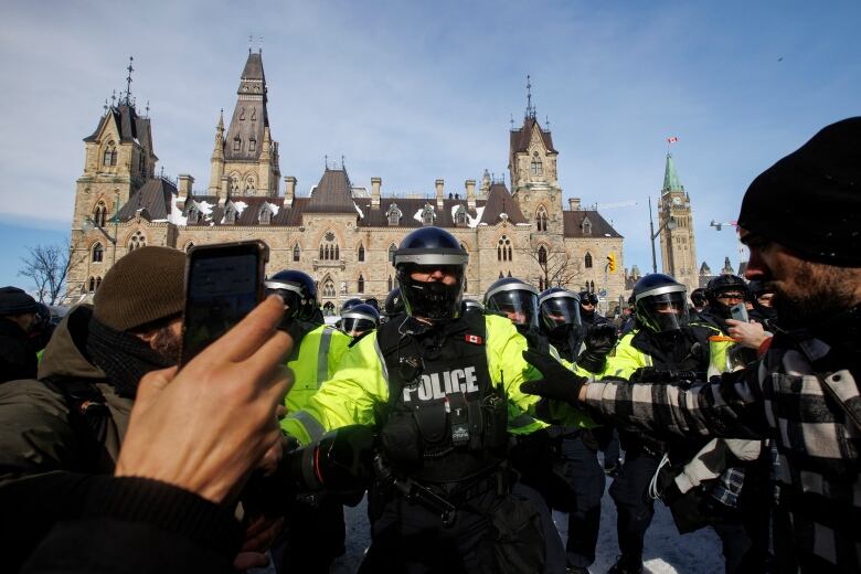 Police enforce an injunction against protesters, some who have been camped in their trucks near Parliament Hill for weeks, on Feb. 19, 2022.